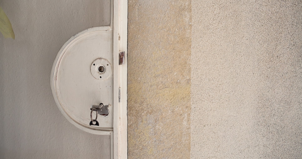 Door to the terrace on the 3rd floor before renovation; semi-circular lock shield in the profile of the steel frame of the door to the terrace used to hold the lock mechanism in place before renovation, 2011, photograph: David Židlický