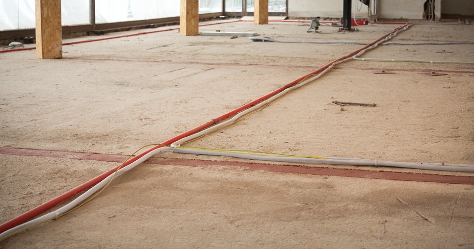 Hlavní obytný prostor (2. NP); nasávací potrubí elektronického požárního systému (červená trubka) a přívodní kabeláž pro podlahové zásuvky (bílé trubky), 2011, foto: David Židlický